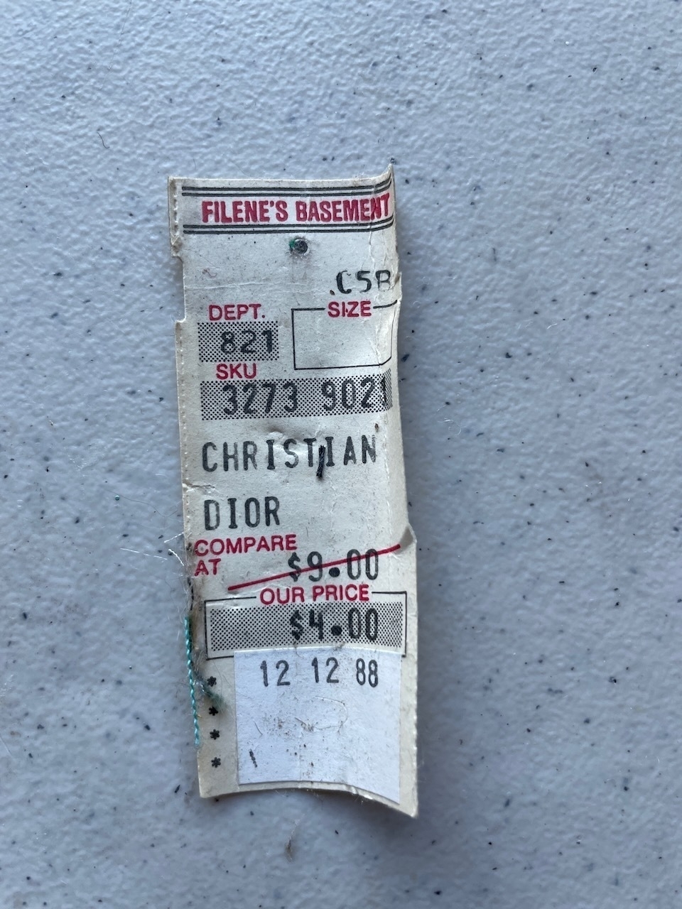 A price tag from Filene's Basement shows a discounted price of $4.00 for a Christian Dior item, dated December 12, 1988.